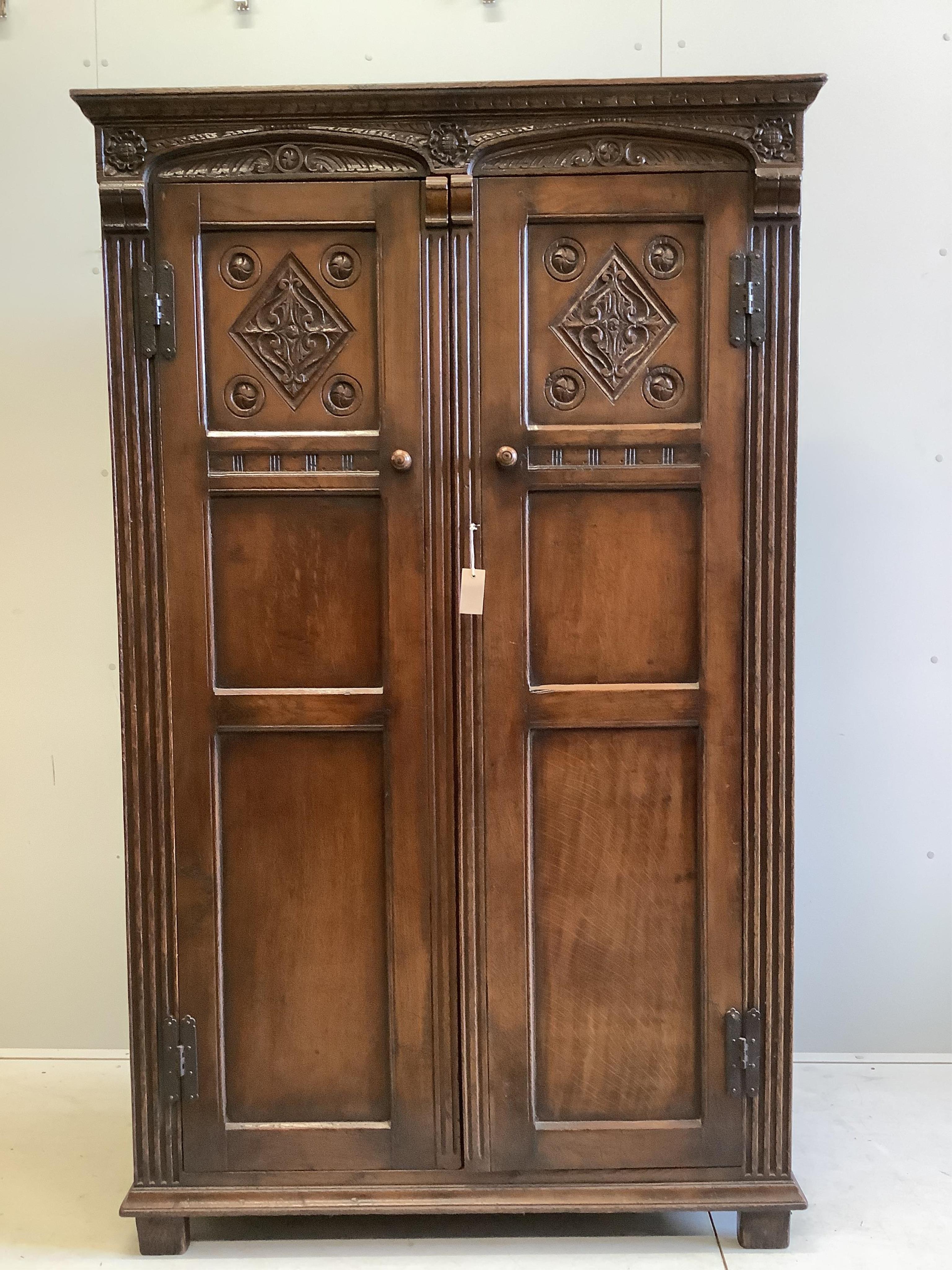 An 18th century style carved oak two door wardrobe, width 112cm, depth 57cm, height 183cm